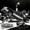 Lowrider car performing hydraulic lift at night with onlookers in monochrome.